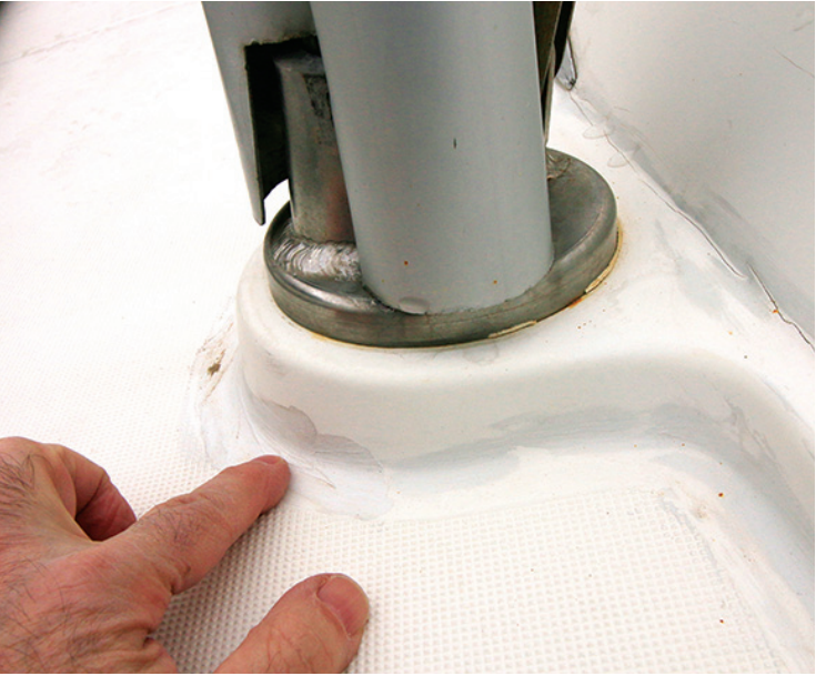 Finger pointing towards paint that has tried to cover up cracking